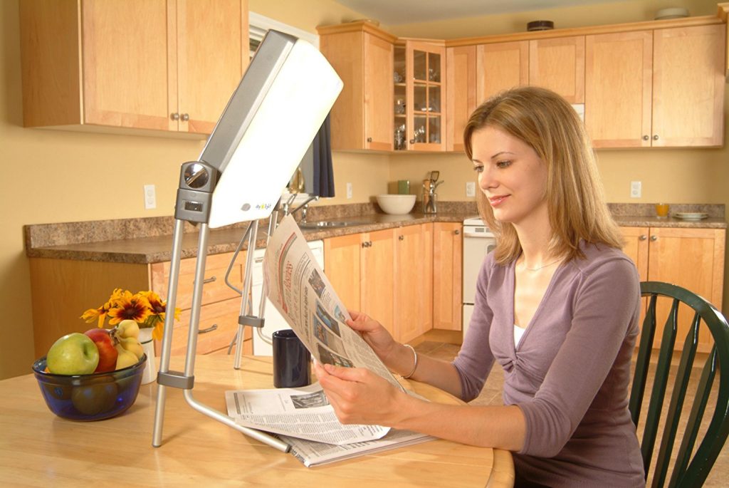 Carex Day-Light being used by a woman to read at the kitchen table